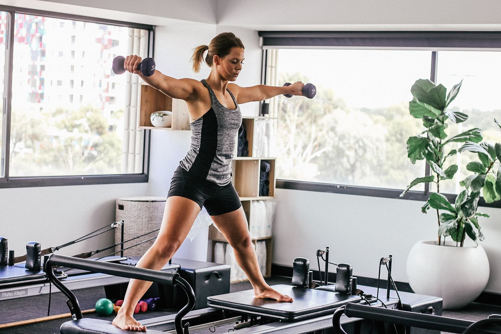 Mujer entrenando sobre un reformer de pilates